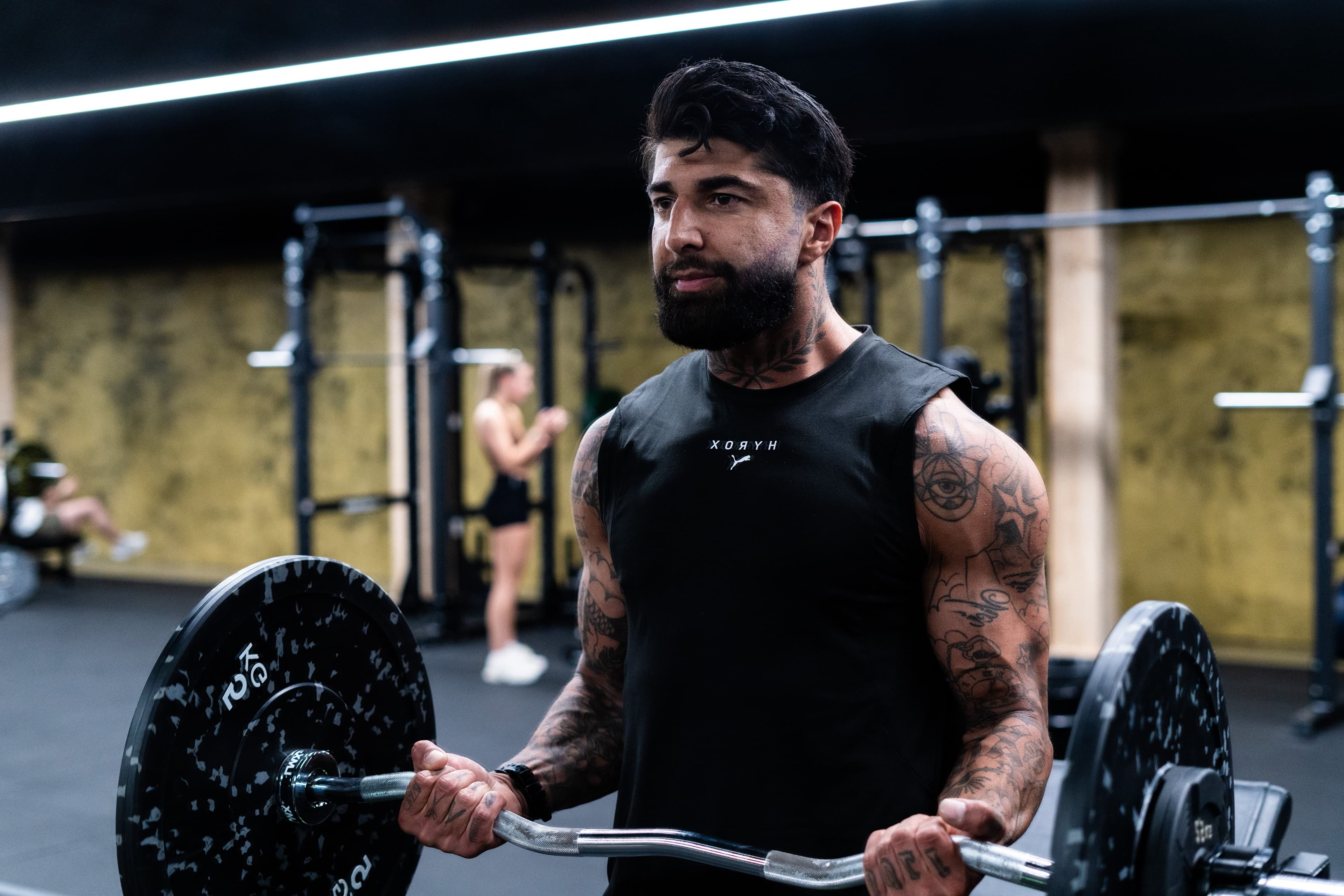 Roman doet biceps curls met een EZ-bar
